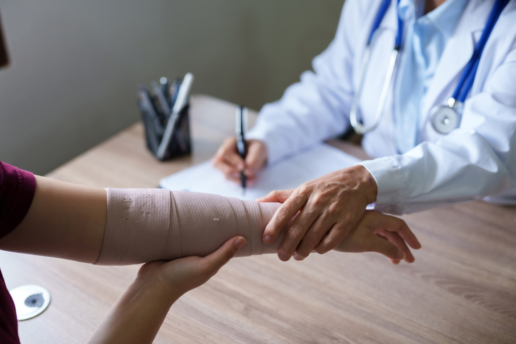 Doctor is examining the arm of a patient who has been in an accident.