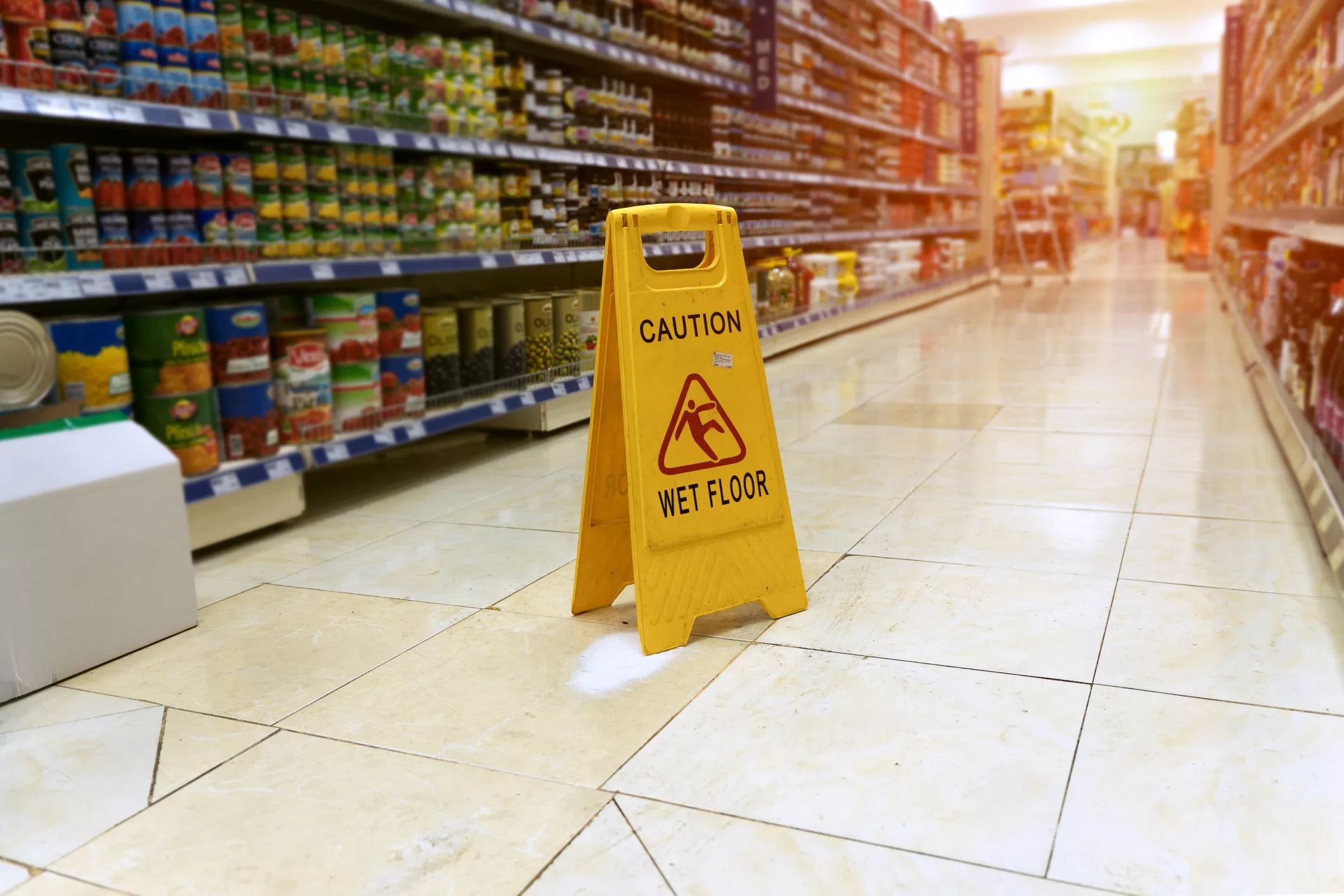 Close-up photo of a caution: wet floor sign in a grocery store aisle