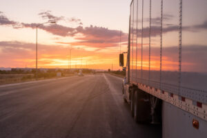 side view of a semi-truck on the highway during a breathtaking sunset
