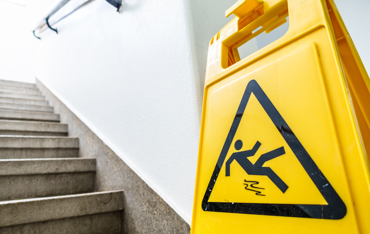 staircase with slip and fall caution sign - nashville premises liability attorney