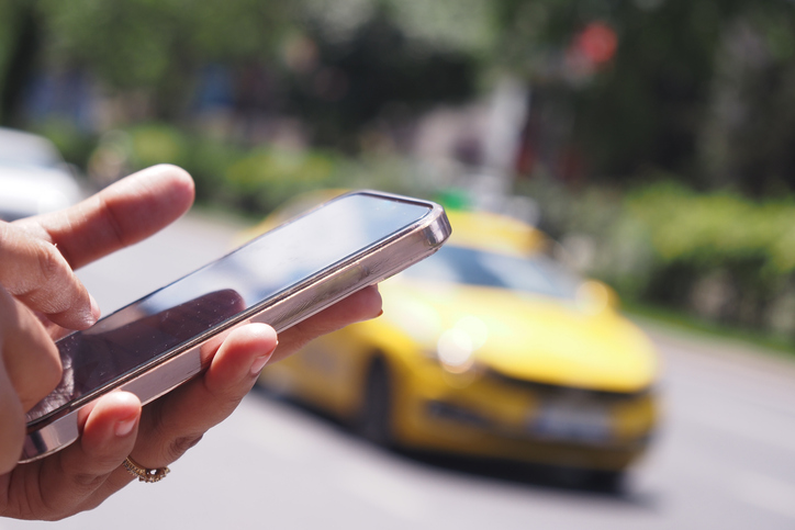 Person requesting rideshare service on phone - Nashville Uber accident lawyer