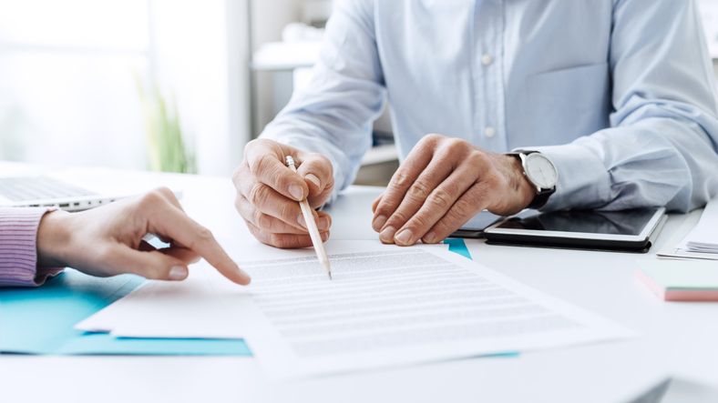 two people reviewing documents - Why is causation difficult to prove?